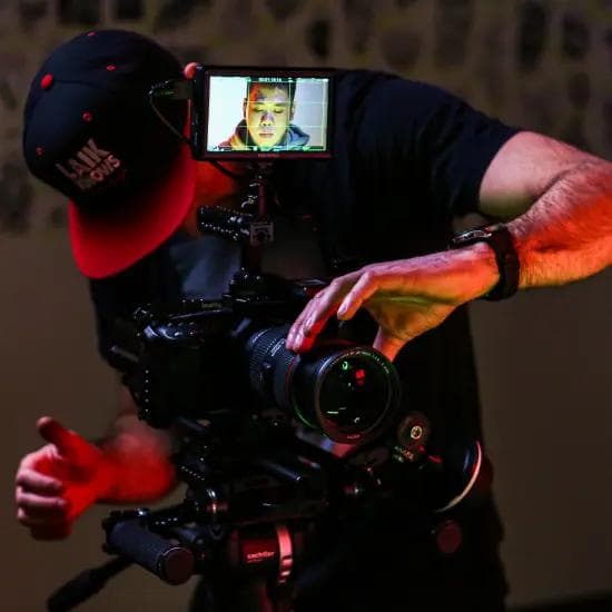 Mężczyzna ustawiający czarną kamerę